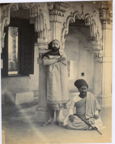 [Photo.35/(057)] Portrait photograph of two Indian men, one standing and one sitting, in an ornate stone interior